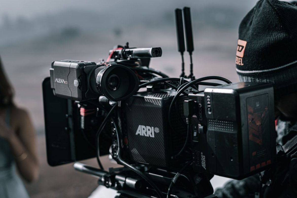ARRI cinema camera on a rig with lens, cables, and external monitor—outdoor filming setup.